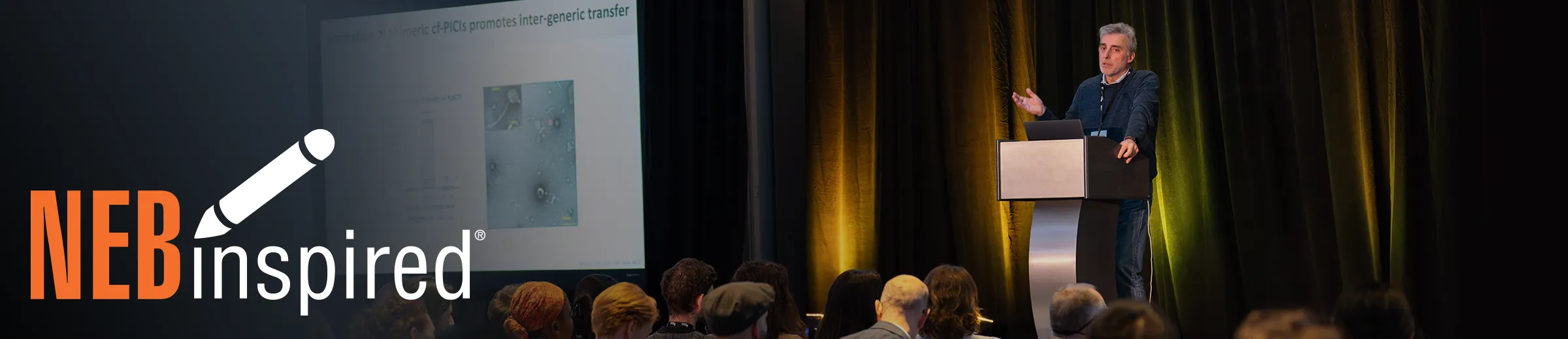 Jose Penades speaking at the 2026 Unorthodox Genomes Symposium, with NEBinspired logo
