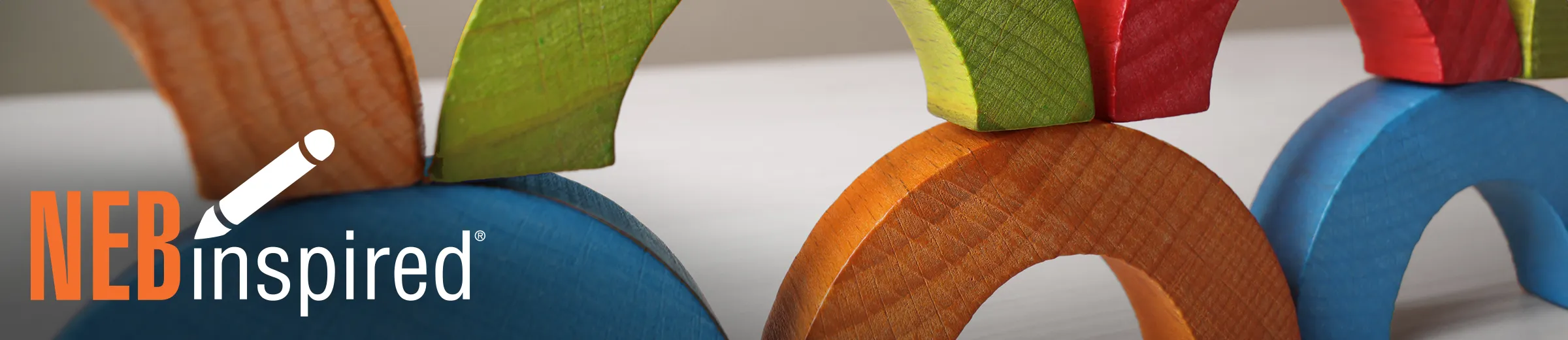 Stack of colorful wooden arch blocks, with NEBinspired logo